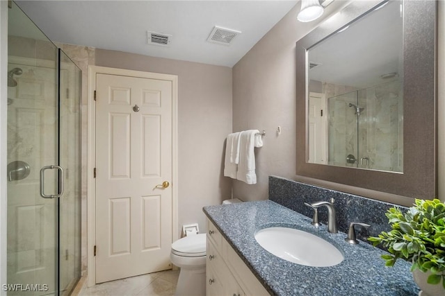 bathroom featuring vanity, a shower with door, tile patterned floors, and toilet