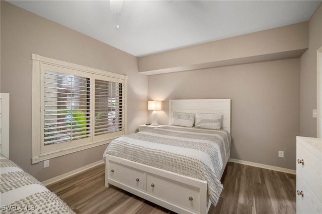 bedroom with dark wood-style floors and baseboards