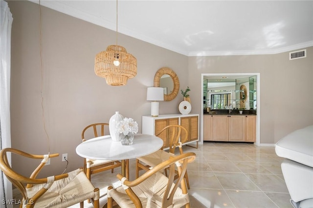 tiled dining space featuring ornamental molding and sink