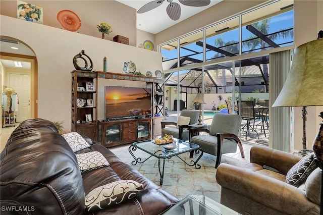 living room featuring a towering ceiling and ceiling fan