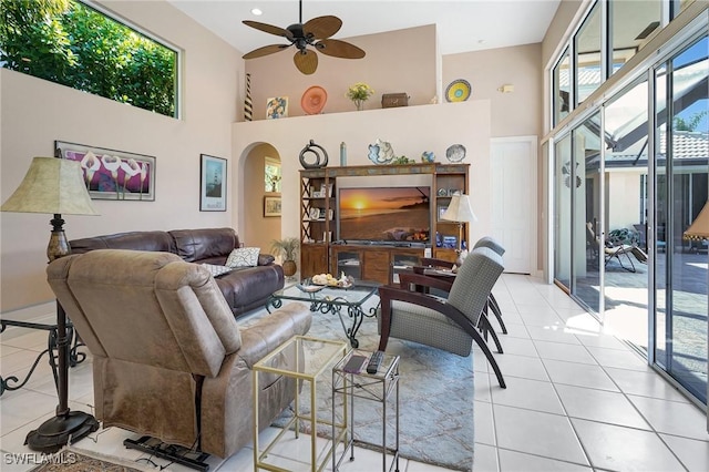 tiled living room featuring ceiling fan and a towering ceiling