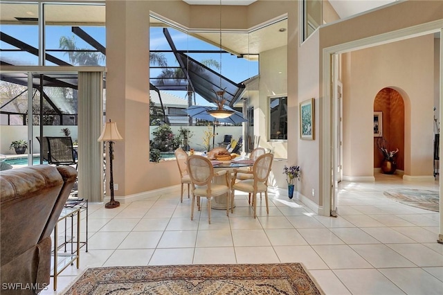 tiled dining space featuring a towering ceiling