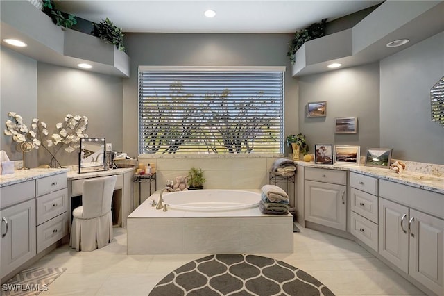 bathroom featuring tile patterned floors, vanity, and tiled tub