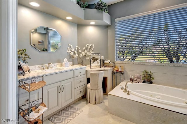 bathroom featuring tile patterned floors, vanity, and tiled tub