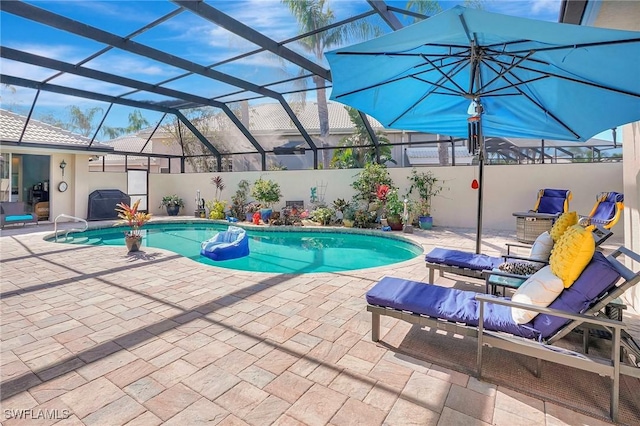 view of swimming pool featuring a patio area and glass enclosure