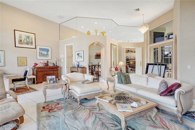 tiled living room featuring a high ceiling and a chandelier