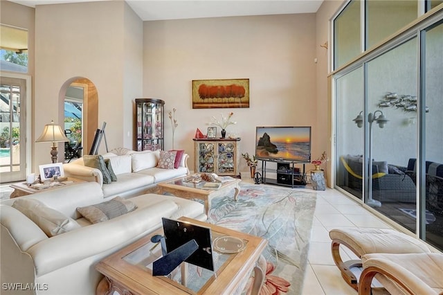 living room featuring light tile patterned floors and a towering ceiling