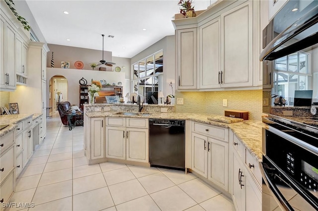 kitchen featuring sink, ceiling fan, black dishwasher, tasteful backsplash, and light stone countertops