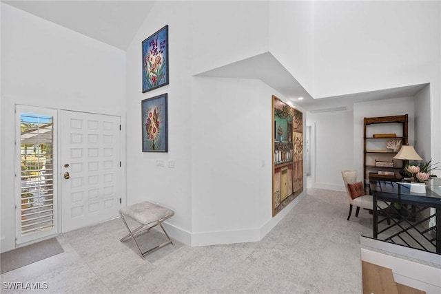 entrance foyer featuring high vaulted ceiling