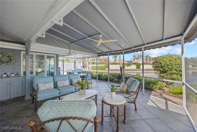 sunroom with lofted ceiling, a healthy amount of sunlight, and ceiling fan