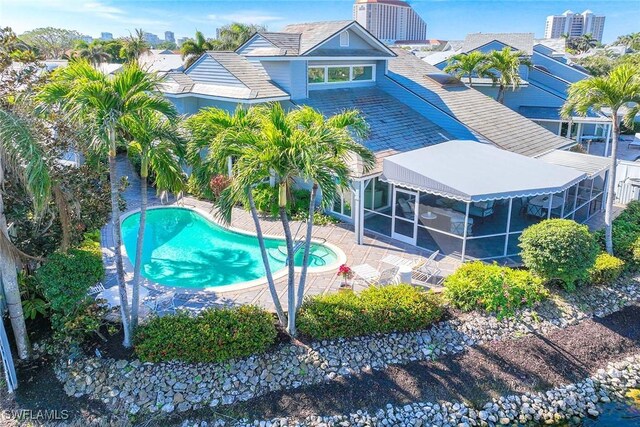 view of swimming pool with a patio area and a sunroom