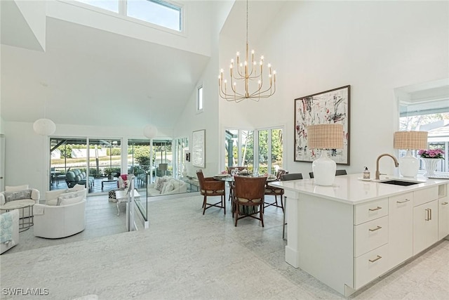 kitchen with pendant lighting, sink, a wealth of natural light, and white cabinets