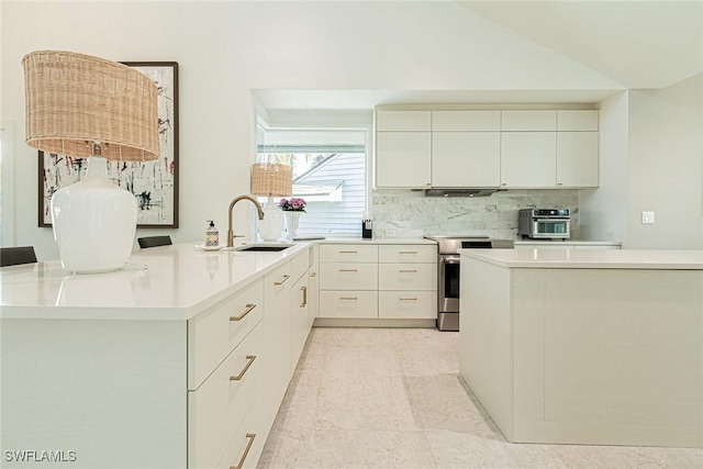 kitchen with sink, tasteful backsplash, vaulted ceiling, stainless steel electric range, and kitchen peninsula