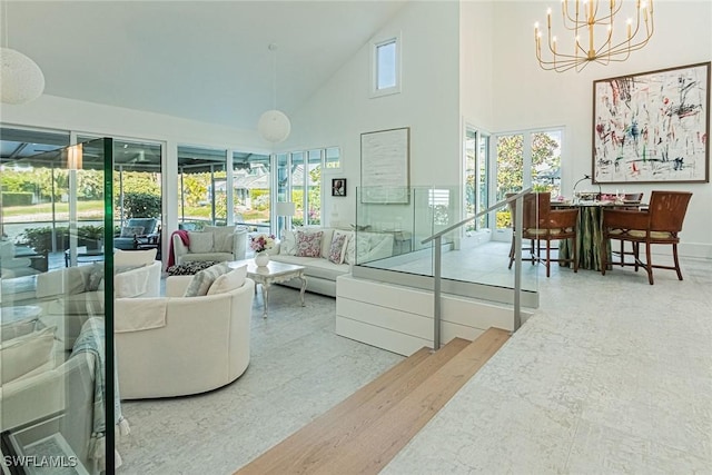 living room featuring plenty of natural light, high vaulted ceiling, and a chandelier