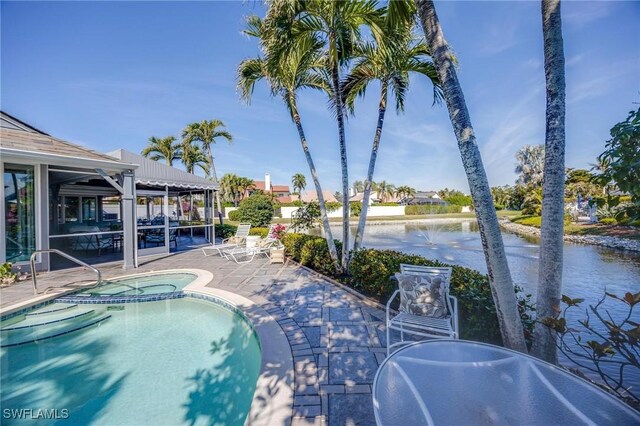 view of pool with a water view, an in ground hot tub, and a patio area