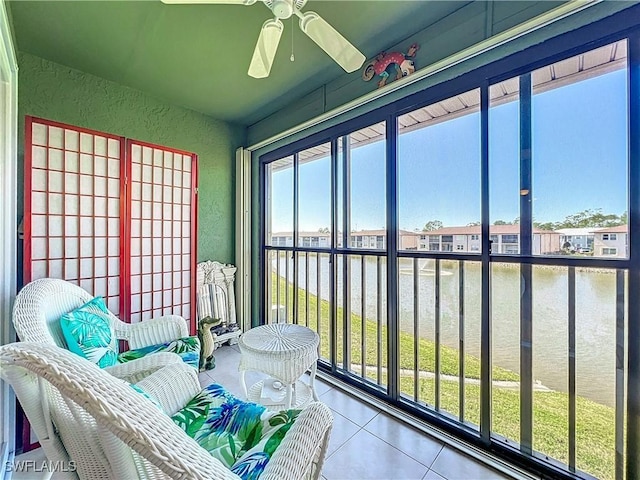 sunroom / solarium with a water view and ceiling fan