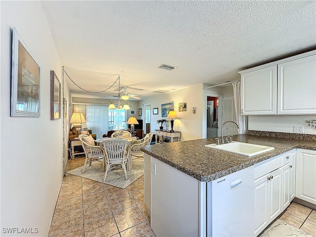 kitchen with dishwasher, white cabinetry, sink, kitchen peninsula, and a textured ceiling