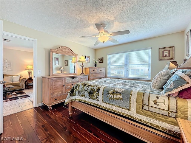 bedroom featuring ceiling fan, a textured ceiling, and dark hardwood / wood-style flooring