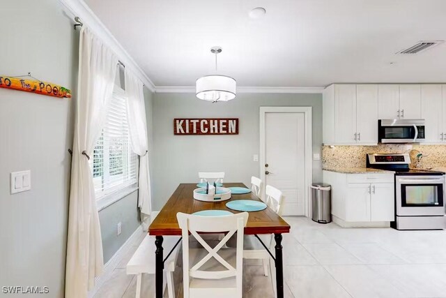 kitchen featuring appliances with stainless steel finishes, decorative light fixtures, white cabinetry, backsplash, and light stone counters