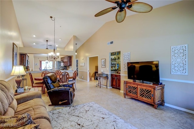 living room featuring high vaulted ceiling and ceiling fan with notable chandelier