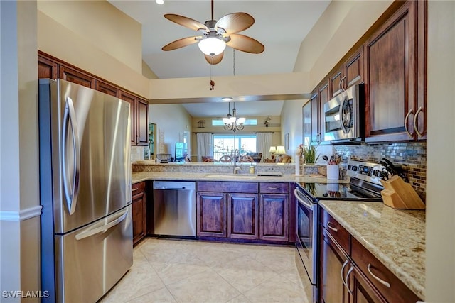 kitchen featuring sink, tasteful backsplash, pendant lighting, stainless steel appliances, and light stone countertops