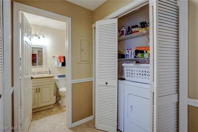 clothes washing area featuring separate washer and dryer, sink, light tile patterned floors, and electric panel