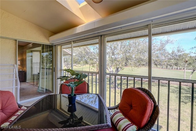 sunroom / solarium featuring vaulted ceiling with skylight