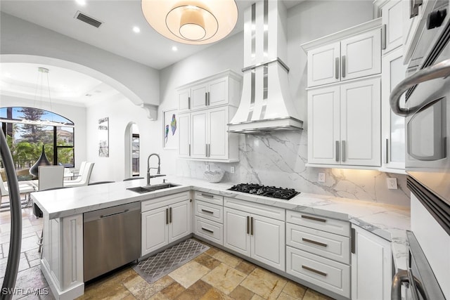 kitchen with sink, white cabinetry, tasteful backsplash, stainless steel dishwasher, and kitchen peninsula