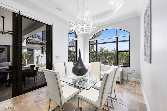 dining room with a notable chandelier, crown molding, and a raised ceiling