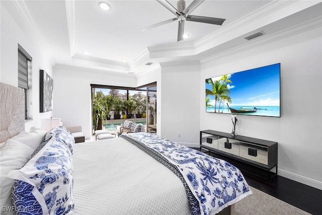 bedroom with dark wood-type flooring, ceiling fan, a tray ceiling, and crown molding