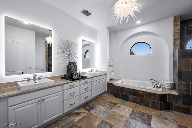 bathroom featuring vanity and tiled bath