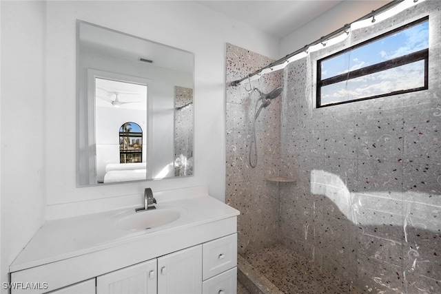 bathroom featuring a tile shower and vanity