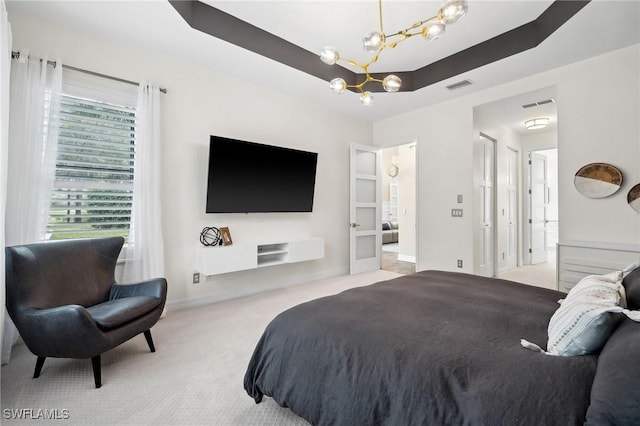 bedroom featuring light carpet, a raised ceiling, and a chandelier