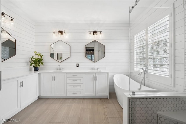 bathroom featuring a healthy amount of sunlight, a bathtub, and vanity