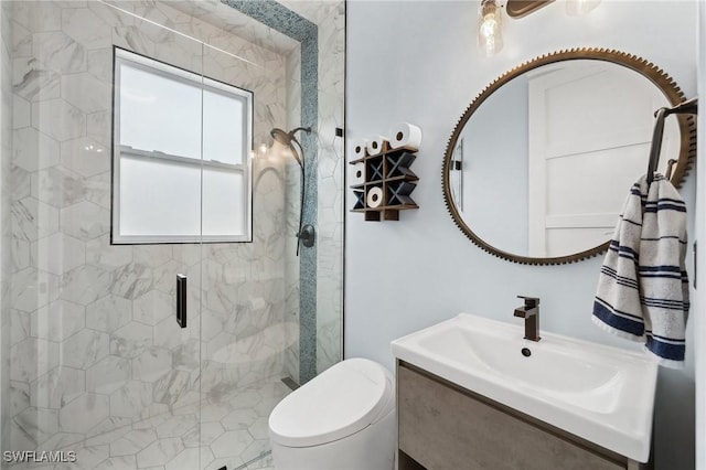 bathroom featuring vanity, toilet, and a shower with door