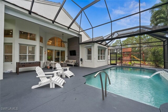 view of swimming pool featuring a lanai, ceiling fan, a patio, a playground, and an outdoor hangout area