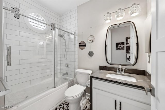 full bathroom with enclosed tub / shower combo, vanity, and toilet