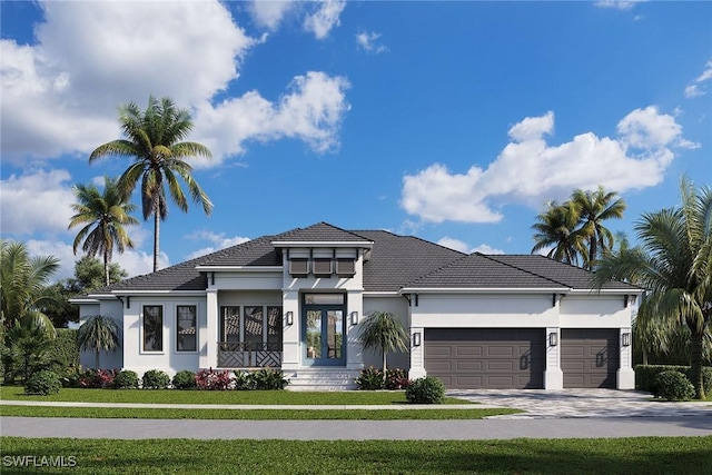 prairie-style house featuring a garage and a front yard