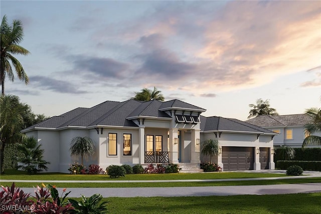 prairie-style home with a yard and a garage