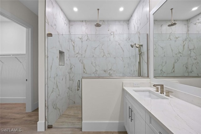 bathroom with an enclosed shower, vanity, and wood-type flooring