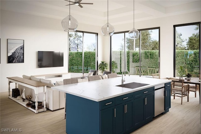 kitchen with an island with sink, sink, pendant lighting, and blue cabinetry