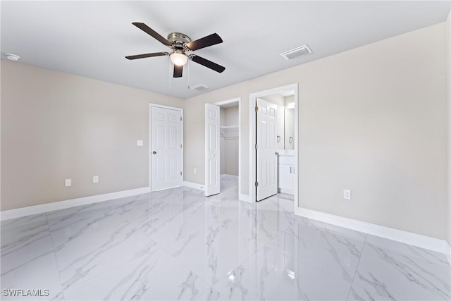 unfurnished bedroom with ensuite bath, ceiling fan, and a closet