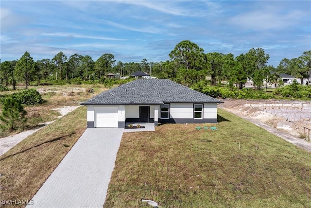 ranch-style house featuring a garage and a front lawn