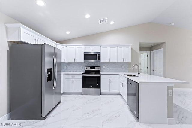 kitchen featuring sink, vaulted ceiling, appliances with stainless steel finishes, kitchen peninsula, and white cabinets