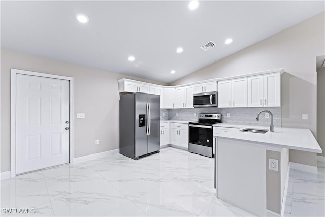 kitchen with lofted ceiling, sink, white cabinets, kitchen peninsula, and stainless steel appliances