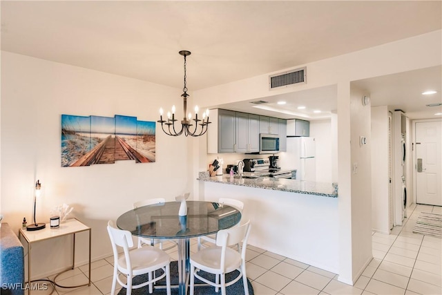 dining area with a notable chandelier and light tile patterned floors