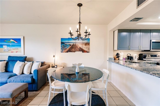 tiled dining space with sink and a notable chandelier