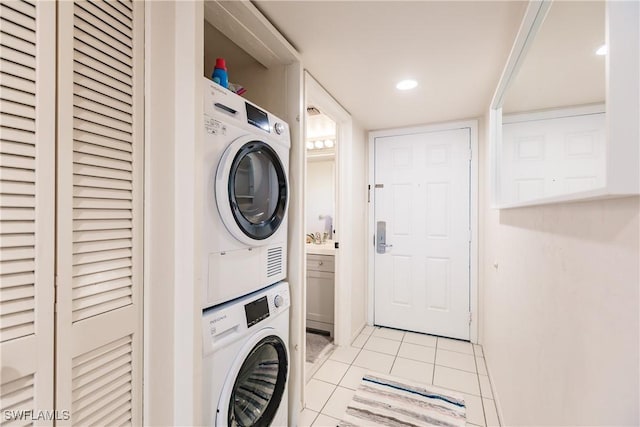 clothes washing area with stacked washer and clothes dryer and light tile patterned floors