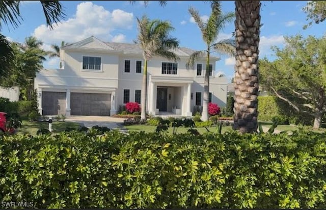 565 Anchor Rode Dr, Naples, FL 34103 - rear view of house featuring a garage, stucco siding, and driveway