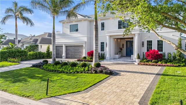 565 Anchor Rode Dr, Naples, FL 34103 - view of front of house featuring a front yard, an attached garage, decorative driveway, and stucco siding